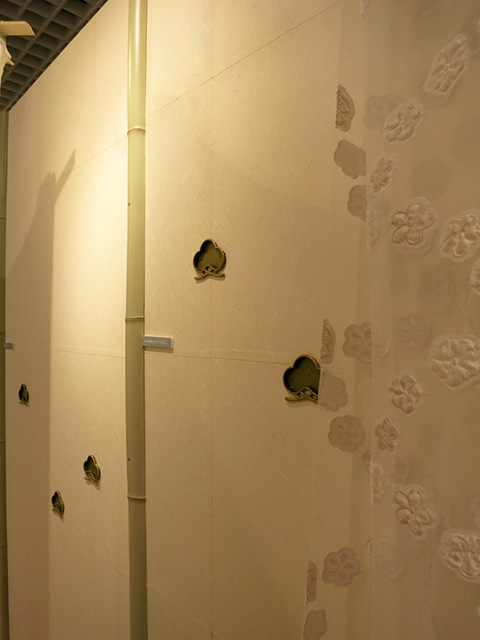 「紙風船」再現ブース 襖紙を重ね貼りした壁に松をモチーフにした引手を埋め込み壁面装飾に